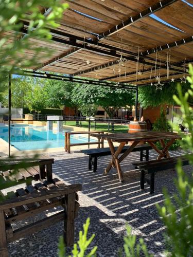 a group of picnic tables and a swimming pool at La Divina Pereza in San Rafael