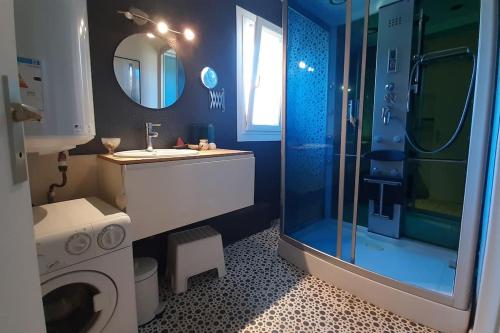 a bathroom with a sink and a washing machine at La maison bleue de Doudou - coeur de village in Castéra-Verduzan