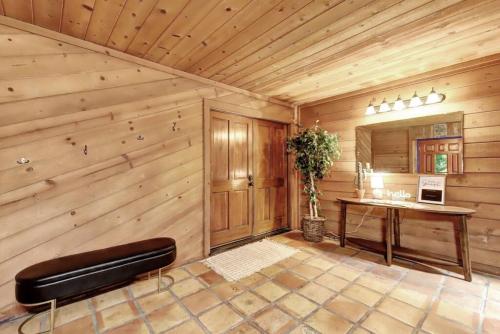 Pokój z drewnianą ścianą ze stołem i ławką w obiekcie Picturesque Cabin Hot Tub w mieście Nevada City