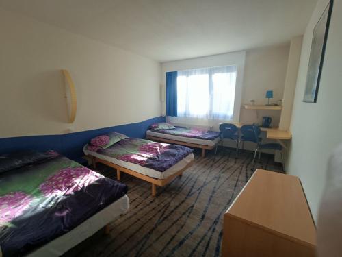 a room with two beds and a table and chairs at Bizzhotel in Szczecin