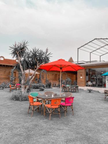 a patio with a table and chairs with an umbrella at Tunis Pyramids Hotel - فندق اهرامات تونس in Tunis