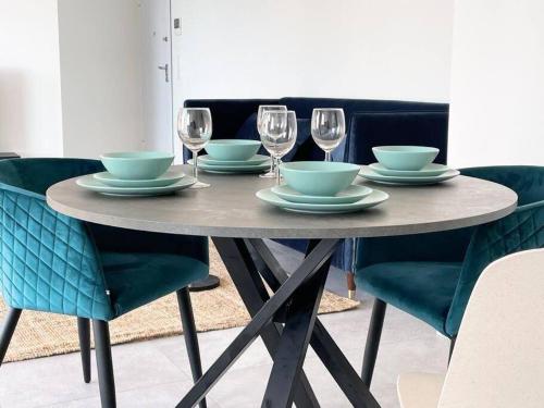 a table with bowls and plates and wine glasses at One bedroom flat with terrace and parking in Luxembourg