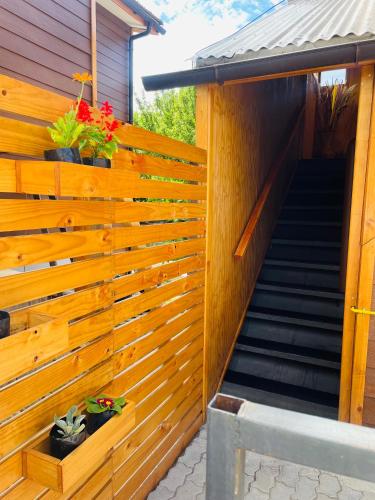 a wooden fence with stairs and flowers on it at Apartamento Coyhaique in Coihaique