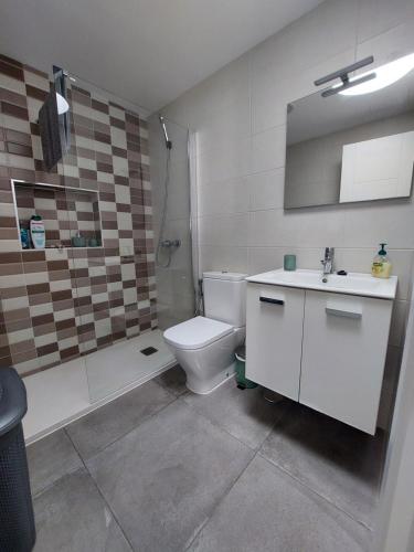 Un baño con inodoro, ducha y lavabo. en CASA ANTONIO Pasillo al Mar 40A, en Costa Teguise