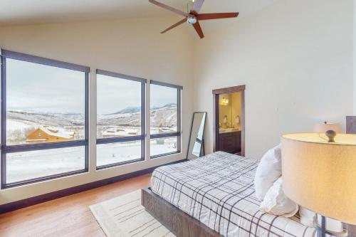 a bedroom with a bed and large windows at A Slice of Silverthorne in Silverthorne