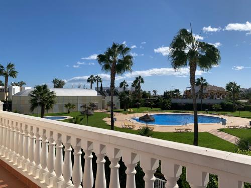 a balcony of a resort with a pool and palm trees at Caroline del Mar - Nudist Naturist in Vera