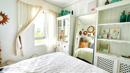 a white bedroom with a bed and a window at Caroline del Mar - Nudist Naturist in Vera