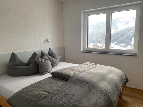a bedroom with a bed with a large window at Apart Mark, Stanz bei Landeck - Moderne Wohnung in sonniger Lage in Stanz bei Landeck