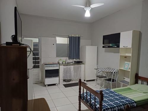 a room with a kitchen with a bed and a table at Flat Itavuvu in Sorocaba