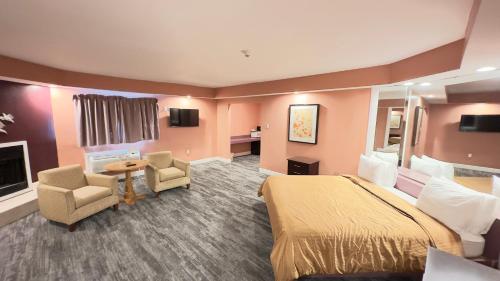 a hotel room with a bed and chairs and a fireplace at Inn of the Dove - Romantic Luxury Suites with Jacuzzi & Seasonal Fireplace at Harrisburg-Hershey-Philadelphia, PA in Harrisburg