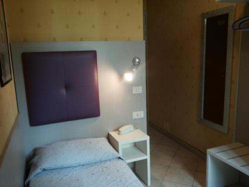 a bedroom with a bed and a phone on the wall at Hotel Le Querce in Milan