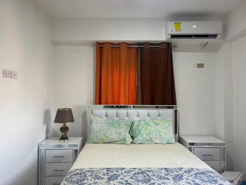 a bedroom with a bed with an orange curtain at Apartamento la Familia in Santa Bárbara de Samaná
