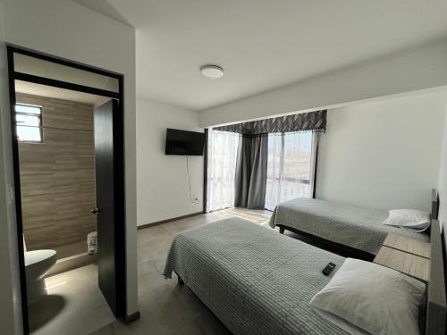 Habitación de hotel con 2 camas y baño en Hotel Santa María, en Iquique
