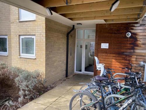 a group of bikes parked outside of a house at Contemporary, Cosy & Homely 2 Bed Apartment with High-Speed WIFI, Terrace & Free Parking overlooking Stourbridge Common Park & Coldham's Brook in Cambridge