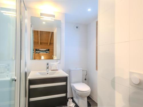 une salle de bain avec toilettes, lavabo et miroir dans l'établissement Super appartement avec parking à Morzine, proche centre et remontées - FR-1-754-25, à Morzine