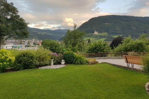 a park bench in a garden with mountains in the background at Ferienhaus am Tullnberg in Mörtelsdorf