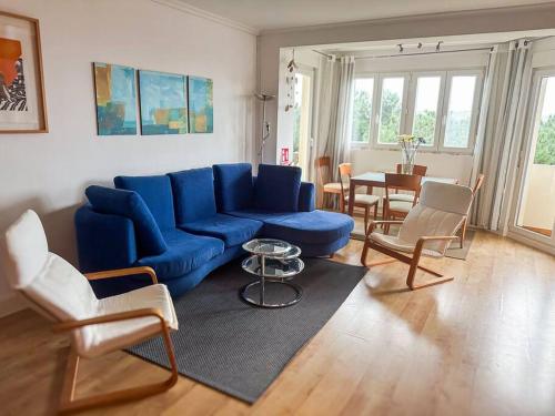 un soggiorno con divano blu e sedie di Apartamento en la playa Mogro con parking privado a Miengo