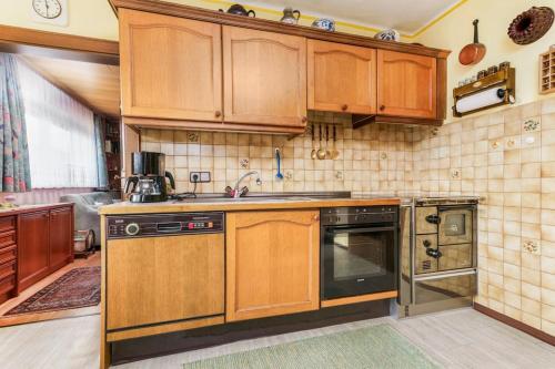 a kitchen with wooden cabinets and a sink at Ferienhaus am Tullnberg in Mörtelsdorf