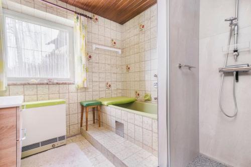 La salle de bains est pourvue d'une baignoire, d'un lavabo et d'une douche. dans l'établissement Ferienhaus am Tullnberg, 