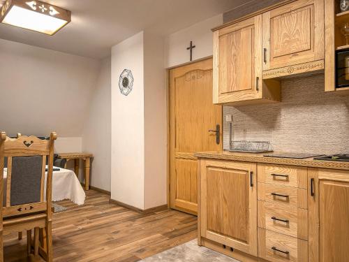 a kitchen with wooden cabinets and a cross on the wall at Gościniec na Równi in Biały Dunajec