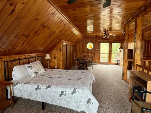 um quarto com uma cama num chalé de madeira em Camp Overlook - Big Moose Lake, NY 