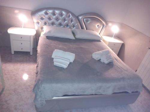 a bedroom with a large bed with two white towels at La Casa Di Giorgia in Pozzuoli