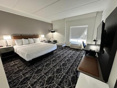 duży pokój hotelowy z łóżkiem i oknem w obiekcie La Quinta by Wyndham Houston Bush IAH South w mieście Houston