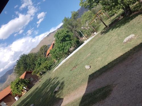 a grassy field with a mountain in the background at Cabañas Nicasio in Merlo