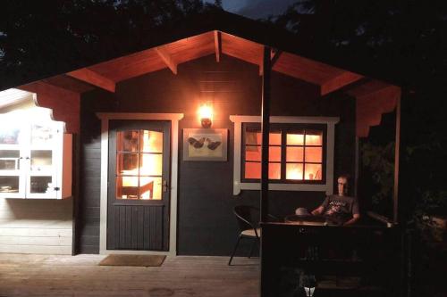 a man sitting in a chair in front of a small house at Unique Tiny House near 3 Peaks - The ZedShed in High Bentham