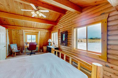 1 dormitorio en una cabaña de madera con cama y ventana en The Log Cabin, en Driggs