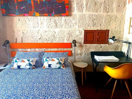 1 dormitorio con cama, mesa y escritorio en Bubamara Bolivar, en Arequipa