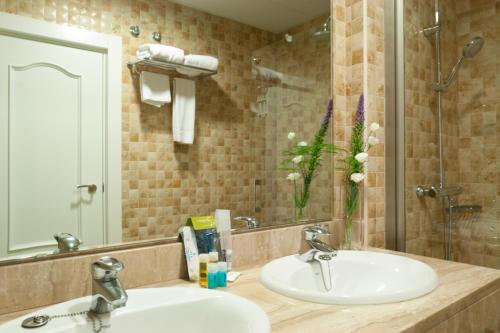 a bathroom with two sinks and a mirror at Hotel Alcázar in Seville