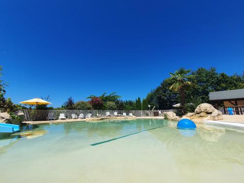 a swimming pool with a blue ball in the water at Gîte Bellevue - Domaine de la chapelle en Corrèze in La Chapelle-aux-Brocs
