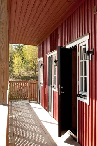 a red building with an open door on a porch at Sju Sjöar in Hyltenäs