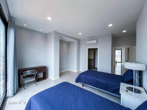 a bedroom with a blue bed and a desk at DEPARTAMENTO DE LUJO in Santa Cruz de la Sierra