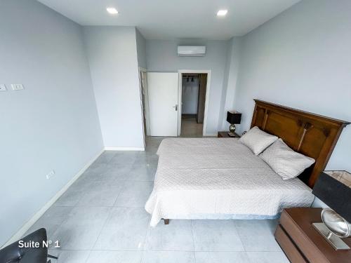 a bedroom with a large bed with a wooden headboard at DEPARTAMENTO DE LUJO in Santa Cruz de la Sierra