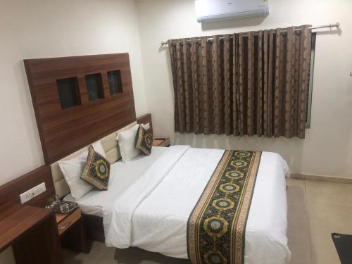a bedroom with a white bed and a window at Hotel Marina in Ahmedabad