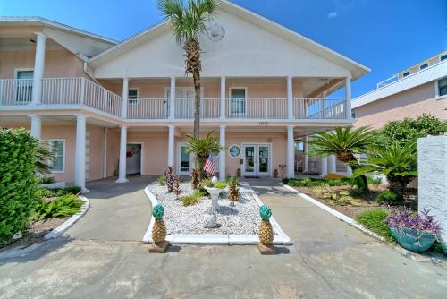 a large pink house with a palm tree in the driveway at Pineapple Villas in Panama City Beach