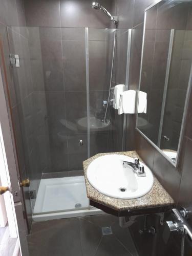 a bathroom with a sink and a shower at Hotel Dunas in Panama City