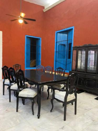a dining room with a black table and chairs at Casa Hacienda Estrada in Campeche