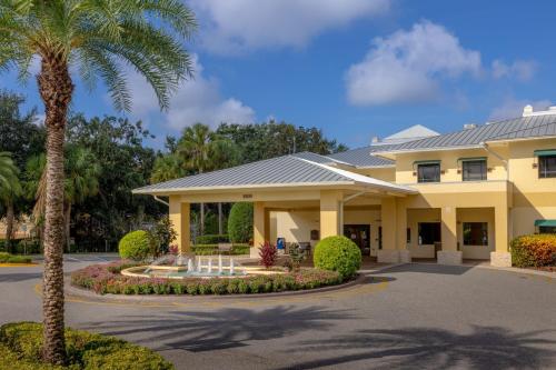 奧蘭多的住宿－Sheraton Vistana Resort Villas, Lake Buena Vista Orlando，棕榈树的大型黄色建筑