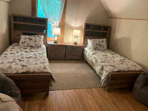 - une chambre avec 2 lits et une fenêtre dans l'établissement Barefoot Cabin, 
