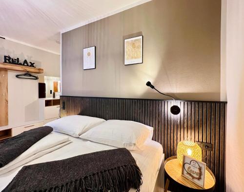a bedroom with a large bed with a wooden headboard at BaMo Studio - city living arkaden in Klagenfurt