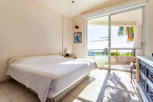 una camera con un letto e una grande finestra di Preciosa Villa en Marina Las Brisas ad Acapulco