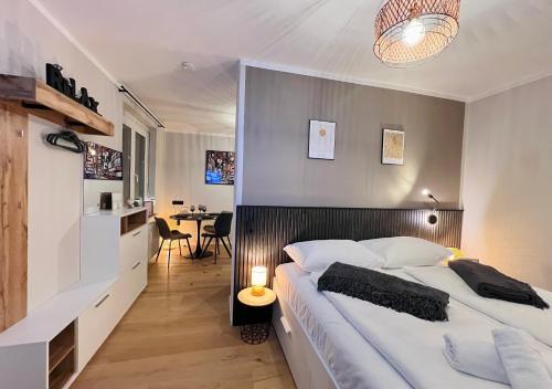 ein Schlafzimmer mit einem großen Bett und einem Tisch in der Unterkunft BaMo Studio - city living arkaden in Klagenfurt am Wörthersee