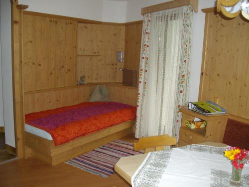 a small bedroom with a bed and a table at Weifer Biobauernhof in Prägraten