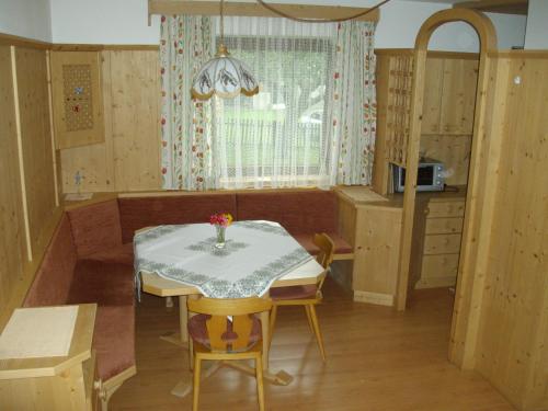 a dining room with a table and chairs and a kitchen at Weifer Biobauernhof in Prägraten