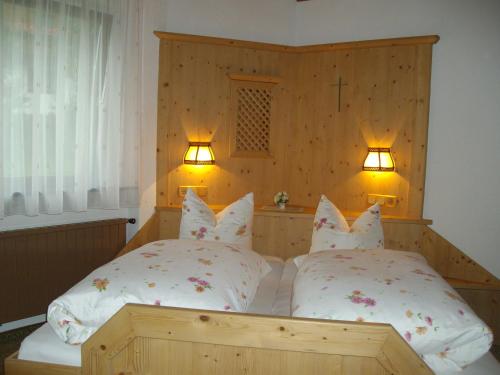 a bedroom with two beds and two lights on the wall at Weifer Biobauernhof in Prägraten