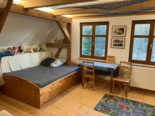 a bedroom with a bed and a desk in it at Chalupa Ostrůvek in Tachov