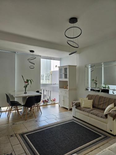 ein Wohnzimmer mit einem Sofa und einem Tisch in der Unterkunft Apartamentos na Praia do Gonzaga in Santos